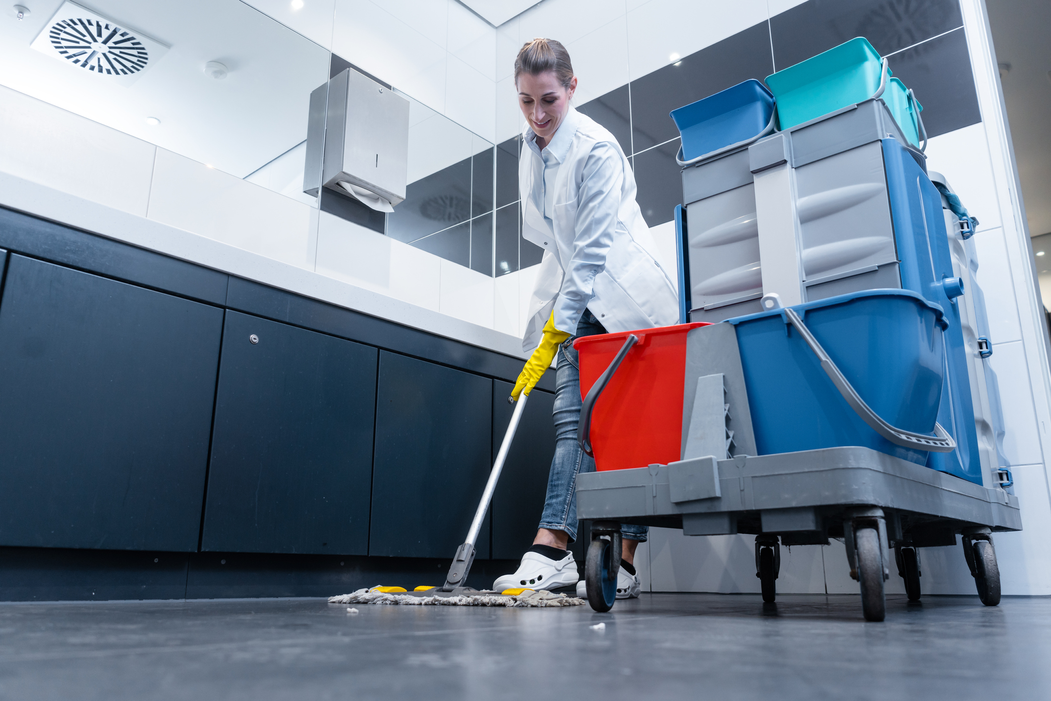 Cleaning lady mopping the floor in restroom Cleaning lady mopping the floor in restroom
